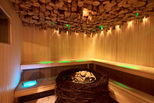 a sauna with a stone wall and green lights at Grand Rose SPA Hotel in Kuressaare