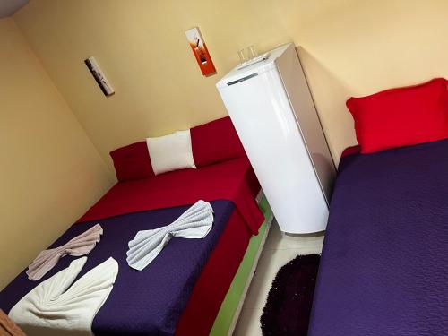 1 dormitorio con 2 camas y nevera en Hotel Boutique Boa Vista, en Boa Vista