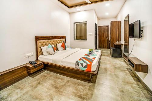 a bedroom with a large bed and a flat screen tv at FabHotel Global Inn I Aurangabad Railway Station in Aurangabad