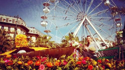 a woman sitting on a bench next to a ferris wheel at Lolli Palace Hotel in Sanremo