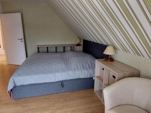 a small bedroom with a bed and a chair at Ferienwohnung mit Seeblick am Groß Labenzer See in Klein Labenz