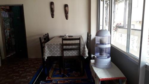 a table and chairs in a room with a window at Vamoose Mendo Lamu Homestay in Darjeeling