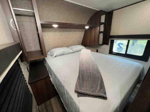 a large bed in the middle of a small room at Rv for up to 6 people in Naples