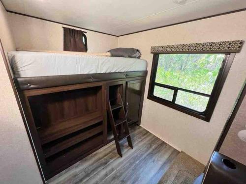 a tiny house with a bunk bed and a window at Rv for up to 6 people in Naples