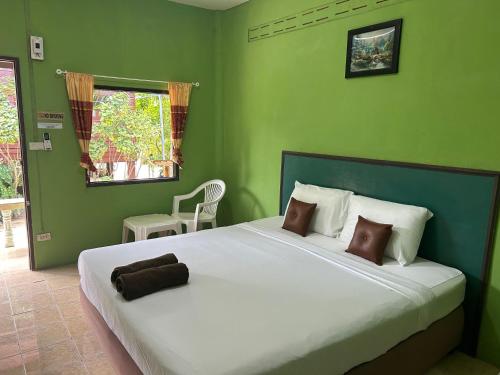 a bedroom with a large bed with green walls at ABC Bungalow in Ban Tai