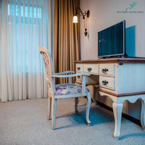 a desk with a chair and a tv on top at Boutique Hotel Baku in Baku