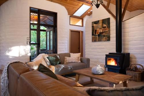 a living room with a couch and a wood stove at Woodland Cottage in Daylesford