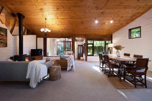 a living room with a wooden ceiling and a table at Woodland Cottage in Daylesford