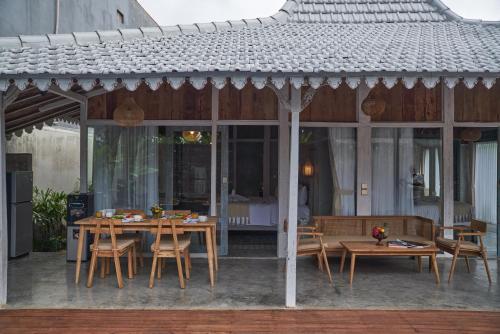 a table and chairs under a pavilion with a table and chairsktop at Casa Batu Belig in Seminyak