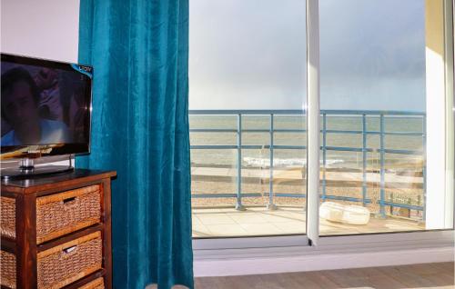a room with a television and a view of the beach at 1 Bedroom Nice Apartment In Wimereux in Wimereux