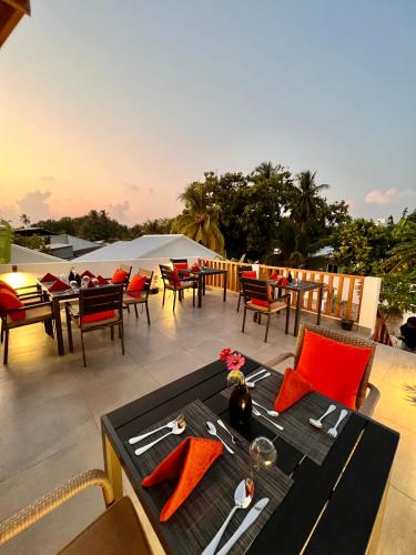 a table and chairs on a patio with tables and chairs at Seaside Dhigurah in Dhigurah