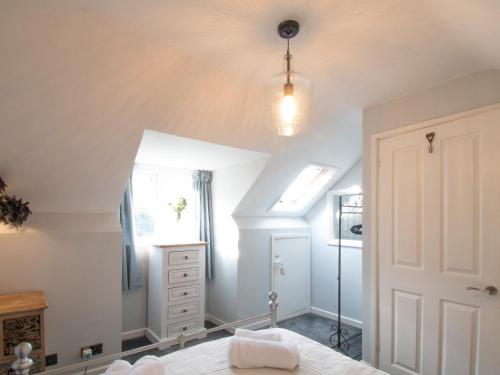 a bedroom with white walls and a ceiling at Blacksmiths Cottage in Uplyme