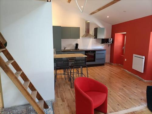 a kitchen with red walls and a red chair in a room at Superbe appartement au cœur du village in Largentière