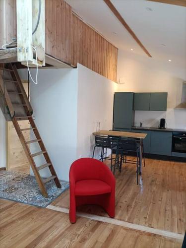 un salon avec une chaise rouge et une table dans l'établissement Superbe appartement au cœur du village, à Largentière