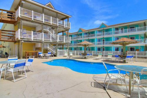 a resort with a pool and tables and chairs at BeachGate CondoSuites and Oceanfront Resort in Port Aransas