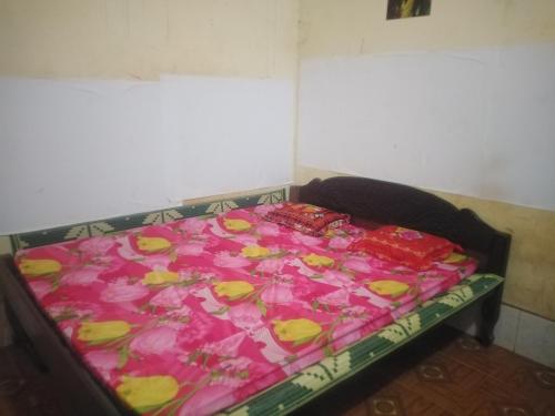 a bed in a room with pink and yellow flowers at Jar rai village homestay& Sona trekking tour in Banlung