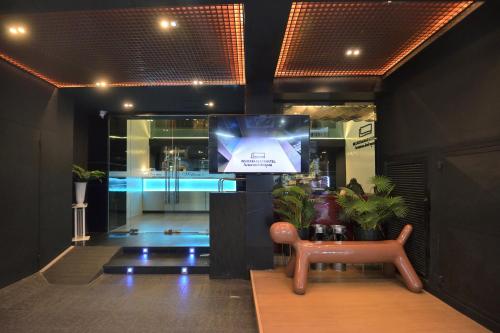 sala de estar con TV en un edificio en De Lux Bangkok Hotel en Ban Khlong Lat Bua Khao