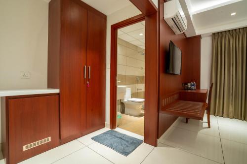 a bathroom with a toilet and a sliding glass door at AS Inn in Cochin