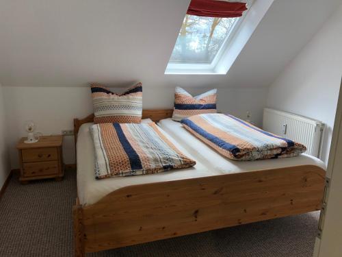 a bedroom with a wooden bed with two pillows at Ferienwohnung Friesenstube in Zetel