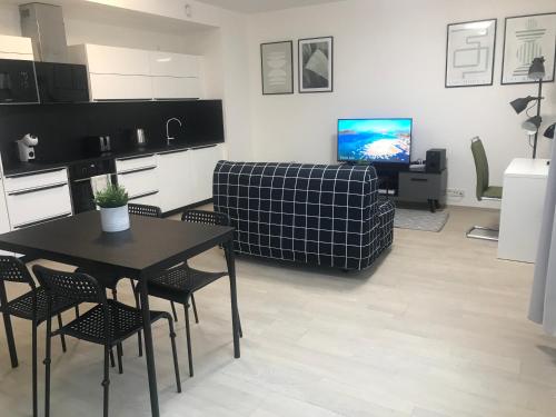 a kitchen and living room with a table and a couch at Apartmantplus01 in Prague