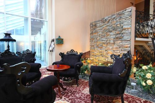 a living room with chairs and a stone fireplace at Grand Rose SPA Hotel in Kuressaare