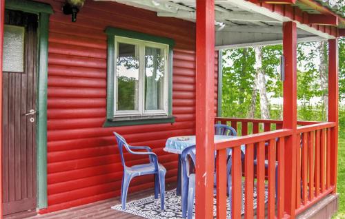 una casa roja con una mesa y sillas en un porche en Pet Friendly Home In Slite With Kitchen, en Gothem