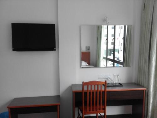 Habitación con escritorio, espejo y silla. en 101 Hotel en Miri