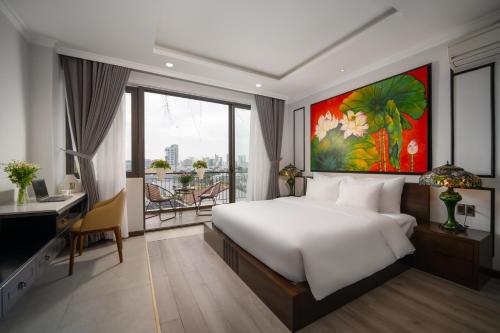 um quarto com uma cama branca, uma secretária e uma janela em Royal 98 Hotel & Apartment em Da Nang