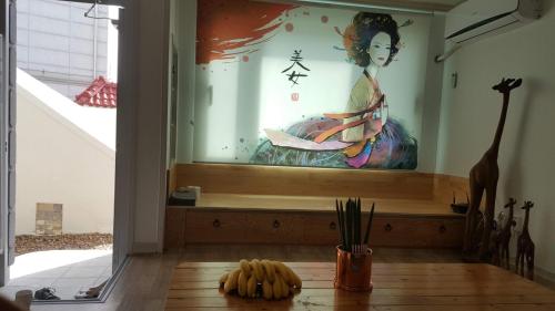 a room with a painting of a woman on the wall at Joa Guesthouse in Gwangju