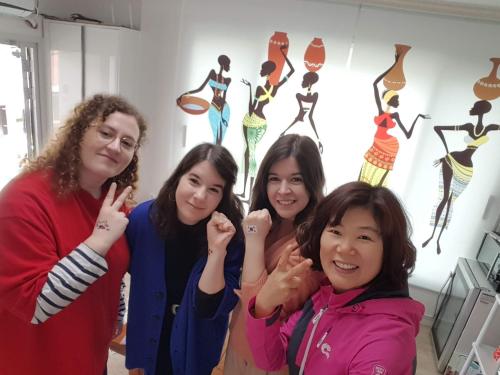 a group of girls posing for a picture in front of some art at Joa Guesthouse in Gwangju