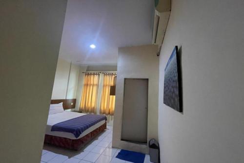 - une petite chambre avec un lit et une fenêtre dans l'établissement OYO 92342 Hotel Batik Traveller, à Medan