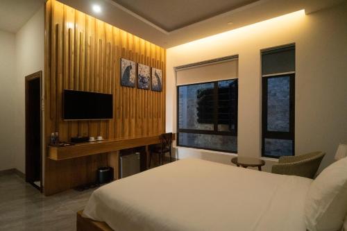 a bedroom with a bed and a television in it at Khách sạn gần biển Karina Phú Yên in Liên Trì (4)