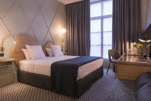 a hotel room with a bed and a window at Millésime Hôtel in Paris