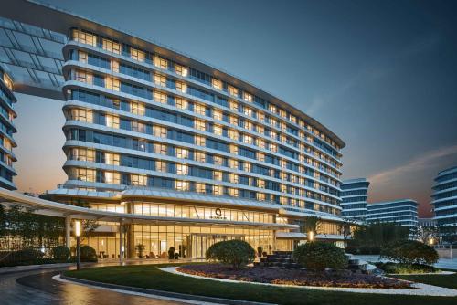 a large building with lights on in a city at The QUBE Hotel Shanghai Hongqiao in Shanghai