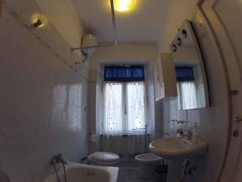 a bathroom with a sink and a toilet and a mirror at B&B Il Cedro in Genoa