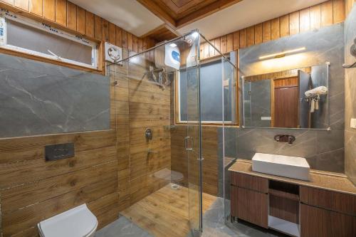 uma casa de banho com um chuveiro, um WC e um lavatório. em Wilderness Whisperings with Himalayan View em Nainital