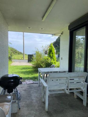 a patio with a bench and a bike in front of a window at 勝浦 高台庭付き 星はとてもキレイ 鳥の鳴き声で目覚め 貸し切り in Katsuura