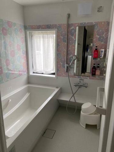 a bathroom with a tub and a toilet and a sink at 勝浦 高台庭付き 星はとてもキレイ 鳥の鳴き声で目覚め 貸し切り in Katsuura