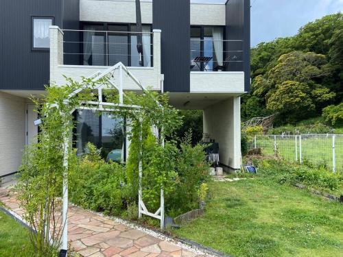 una casa con un jardín delante de ella en 勝浦 高台庭付き 星はとてもキレイ 鳥の鳴き声で目覚め 貸し切り, en Katsuura