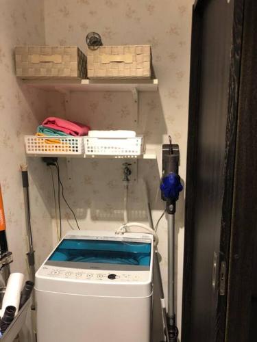 a washing machine in a room with a shelf at 勝浦 高台庭付き 星はとてもキレイ 鳥の鳴き声で目覚め 貸し切り in Katsuura