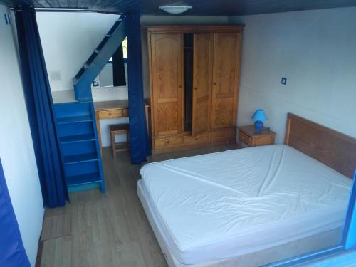 ein Schlafzimmer mit einem Bett und einer blauen Treppe in der Unterkunft Maison flottante sur la seille in Cuisery