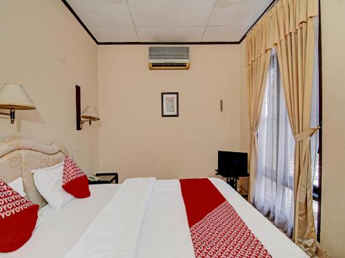 a bedroom with a bed with red and white pillows at OYO 92330 Hotel Rindu Sempadan in Pekanbaru