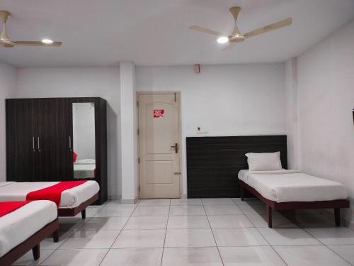 a bedroom with two beds and a mirror at Kings Fort Rooms Thrippunithura in Ernakulam