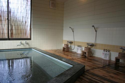 a bathroom with a tub and a swimming pool at Shinpuro in Miyazu