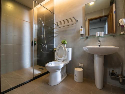 een badkamer met een toilet, een wastafel en een douche bij 48-6 Homestay in Xincheng