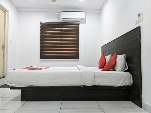 a bedroom with a large bed with red pillows at Kings Fort Rooms Thrippunithura in Ernakulam