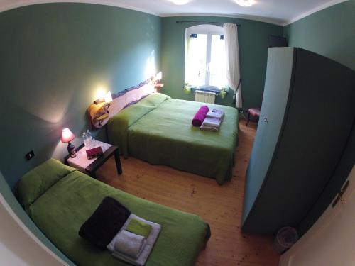 a green bedroom with two beds and a couch at B&B Il Cedro in Genoa