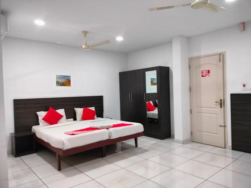 a bedroom with a bed with red pillows on it at Kings Fort Rooms Thrippunithura in Ernakulam