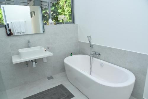 Eldezo Relax Paradise (Pvt) Ltd في بينتوتا: حمام مع حوض أبيض ومغسلة