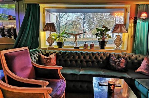 a living room with a couch and a window at Hotel Wassilioff - Unike Hoteller in Stavern